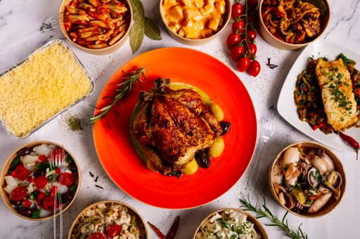 A top view of a table with various delicious homemade dishes in takeaway boxes