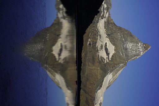 A vertical shot of the Matterhorn mountain reflecting in Rifelsee on the Italian-Swiss border