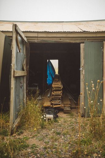 A vertical image of a shed for storing lumber, iron and other materials