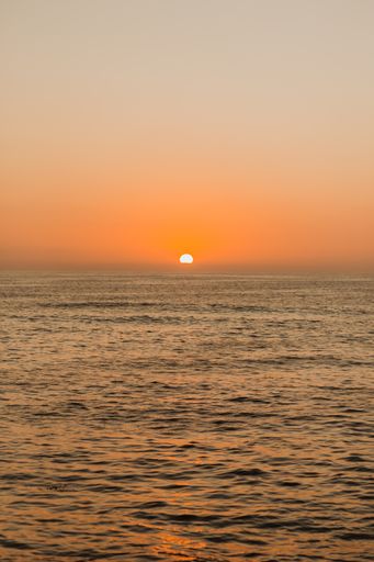 A vertical image of a beautiful orange sunset at the ocean