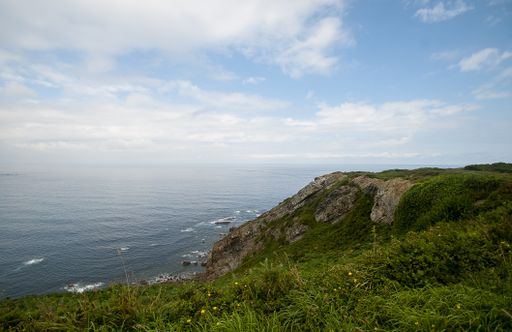A high angle shot of a beach surrounded with cliffs captured on a bright day