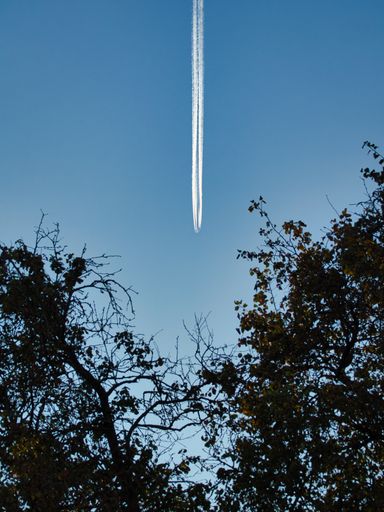 A bottom view of a beautiful blue sky with traces of plane