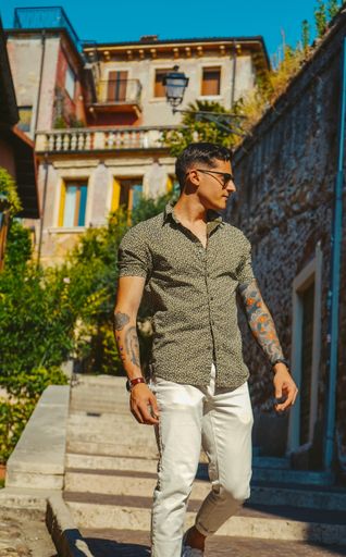Candid shot of model walking down streets of Verona, Italy with balcony in background