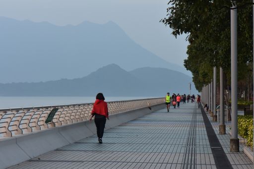 People walking along the embankment in the evening during the sunset in winter