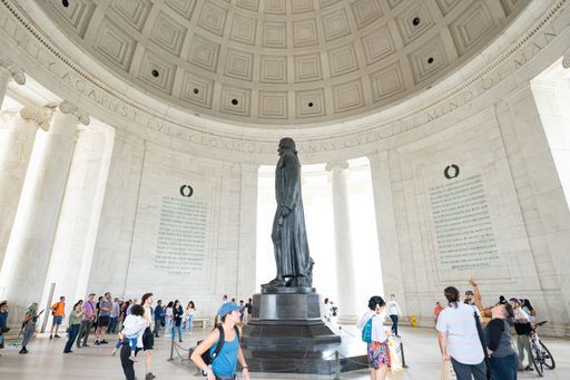 A wide-angle photo of the crowds of people viewing the statue of Thomas Jefferson from inside the dome of the Jefferson Memorial.