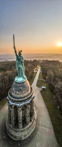 A vertical shot of the Hermannsdenkmal monument on a hill at the sunset in Detmold, Germany