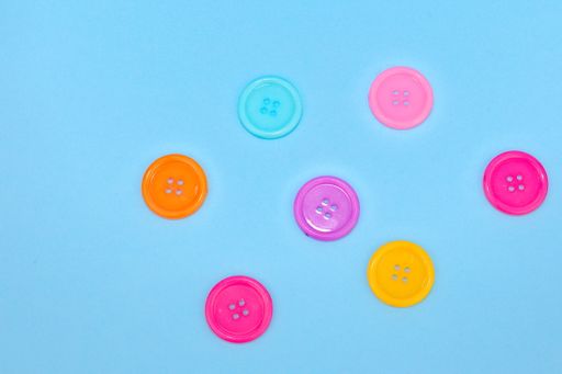 A closeup shot of colorful buttons isolated on the blue background