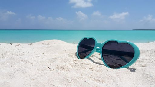 A closeup shot of sunglasses on the beach