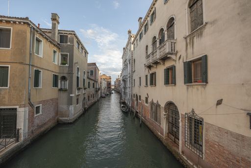 An aerial shot of a river going between buildings in Venice, Italy