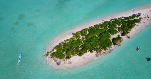 An aerial view of island surrounded by emerald water in Maldives