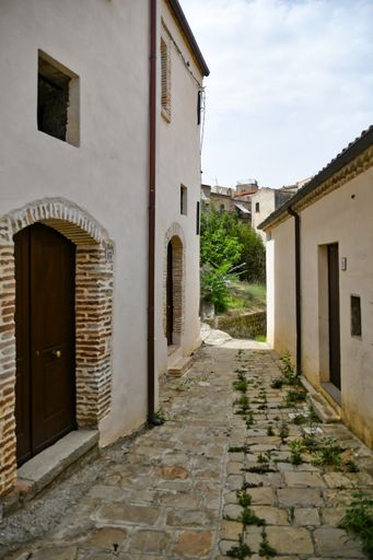 A beautiful shot of a narrow street and traditional houses in Aliano village on a sunny day in Basilicata, Italy.