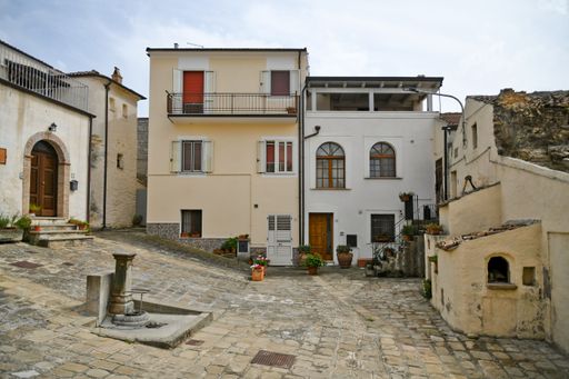 A beautiful shot of a narrow street and traditional houses in Aliano village on a sunny day in Basilicata, Italy.
