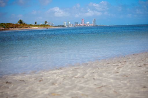 A beautiful view of the calm ocean gleaming under the cloudy blue sky on the coast