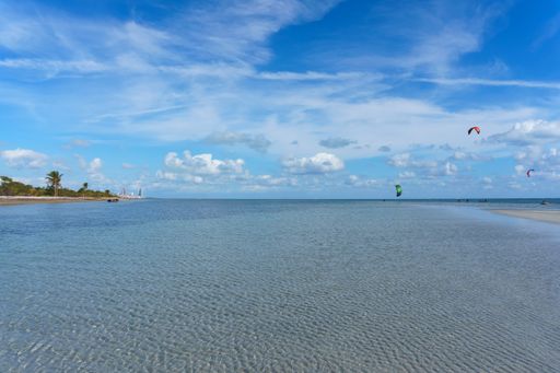 A beautiful view of the calm ocean gleaming under the cloudy blue sky on the coast