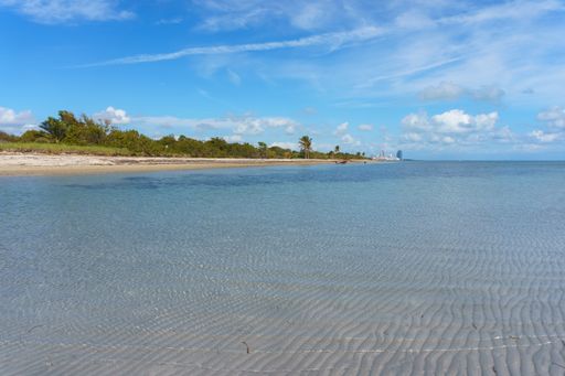 A beautiful view of the calm ocean gleaming under the cloudy blue sky on the coast