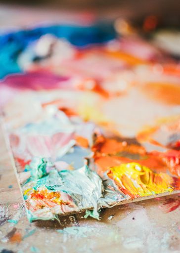 A vertical closeup shot of colorful paint smudges on a blurred background