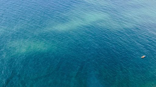 A drone high angle shot of a luxury yacht anchored on tropical exotic turquoise sunny water