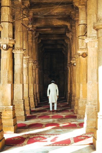 A vertical shot of a man walking in Jama Mosque, India