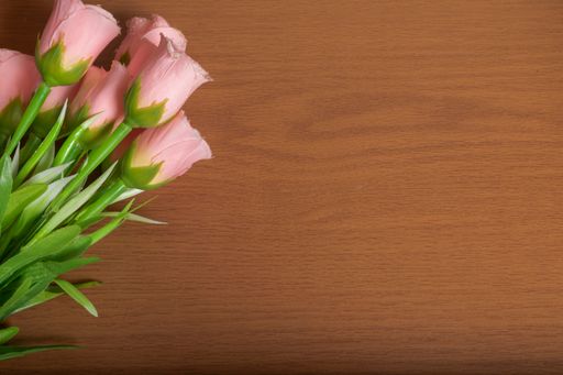 A closeup shot of pink tulips on the wooden background