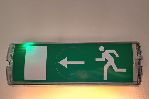 A closeup of an emergency exit sign on the wall