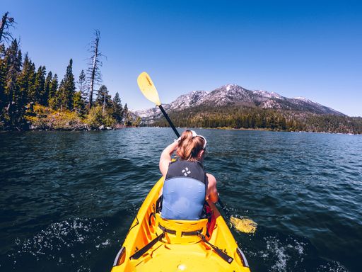 A rear view of a female kayaking on the river
