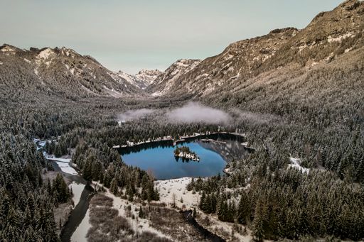 An aerial picturesque view of the Gold Creek Pond surrounded by mountain forests