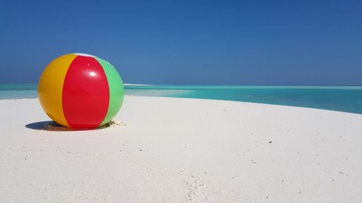A colorful ball on a sandy beach