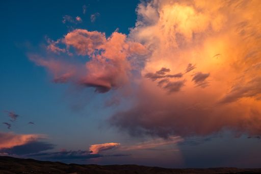 A breathtaking landscape view of orange dramatic clouds of dusk sky at sunset