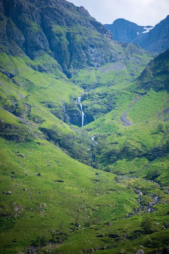A vertical shot of a river flowing between the hills