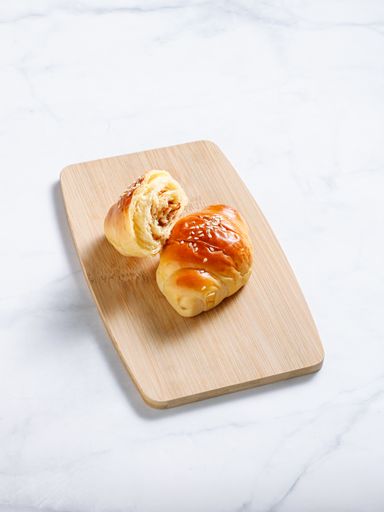A vertical shot of croissants on wood board on white background