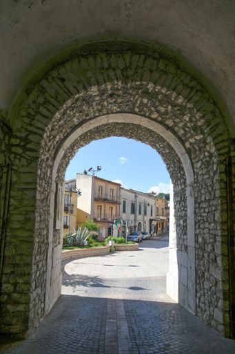 A vertical shot of a narrow alley between medieval stone buildings in Torrecuso, Italy