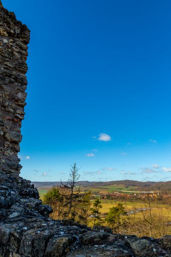 A beautiful shot from Brandenburg castle ruins to green fields in Germany with a blue sunny sky