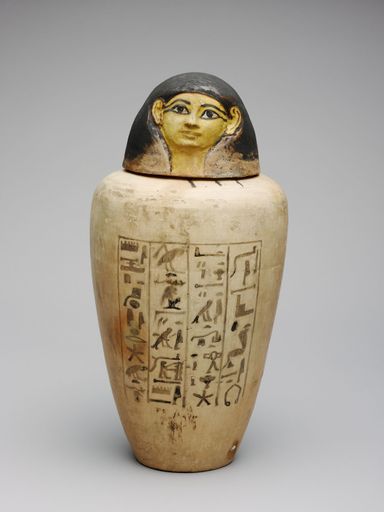A vertical shot of an ancient Egyptian pot with hieroglyphics