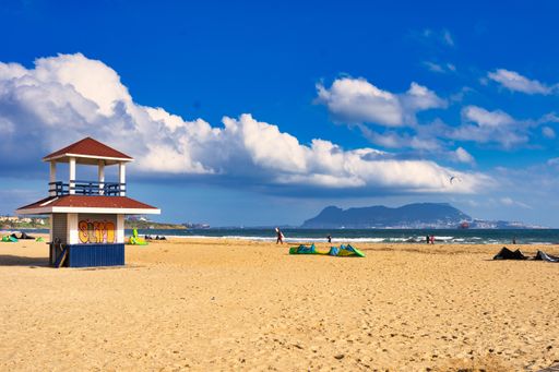 A beautiful sandy beach with a lifeguard station near the ocean