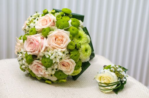 A green pink rose bouquet and a white rose decoration on a table