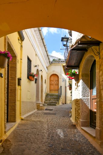 A vertical shot of a narrow street between the old houses of Sant'Agata di Puglia, Italy