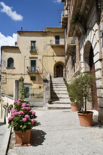 A vertical shot of a narrow street between the old houses of Sant'Agata di Puglia, Italy