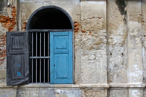 The blue wooden door with an arc of an old worn out building