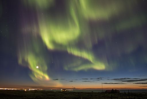 Intense aurora borealis over a small city in Iceland