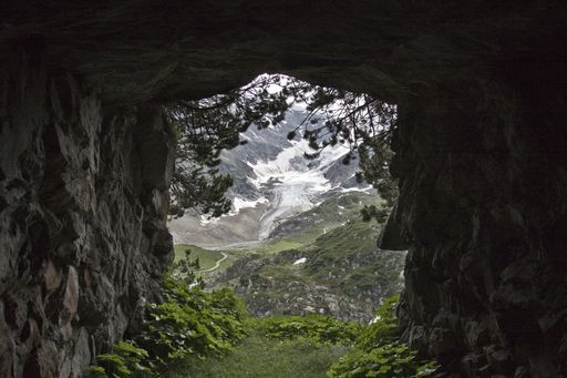 A view of a mountain covered with snow seen from a tunnel