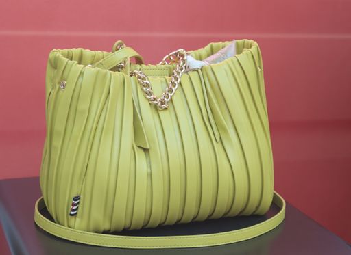 A shot of a yellow female handbag on display with red background