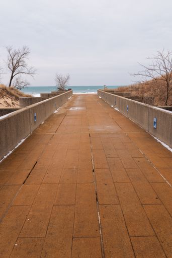 A vertical shot of a pier in Indiana Dunes National Park, Indiana, USA, Lake Michigan, Great Lakes in winter