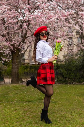 A vertical shot of a young lady posing with tulips