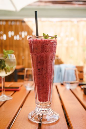 A vertical closeup shot of berry smoothie on wooden table