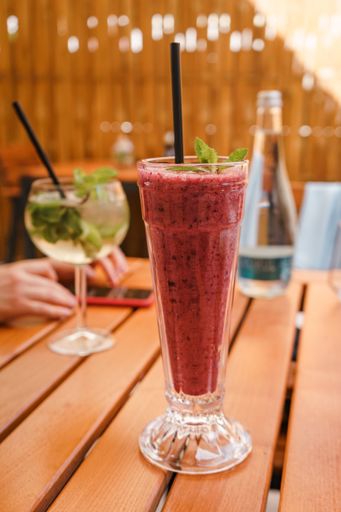 A vertical closeup shot of berry smoothie on wooden table