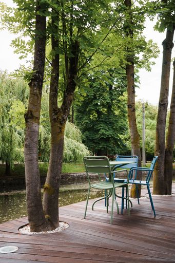 A vertical shot of empty tables and chairs restaurant's outdoor seating area