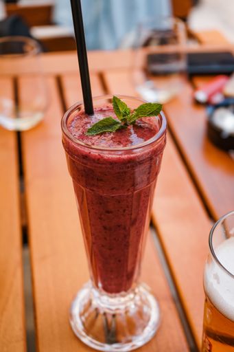 A vertical closeup shot of berry smoothie on wooden table