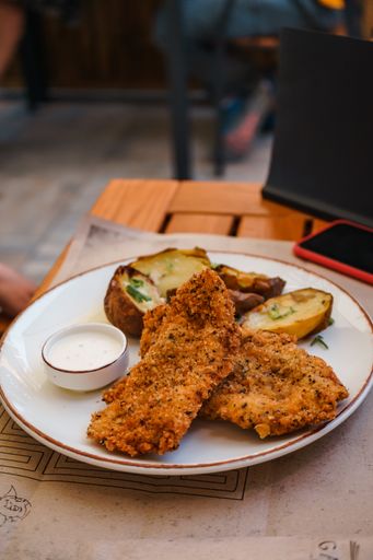A vertical shot of a fried chicken on a white plate