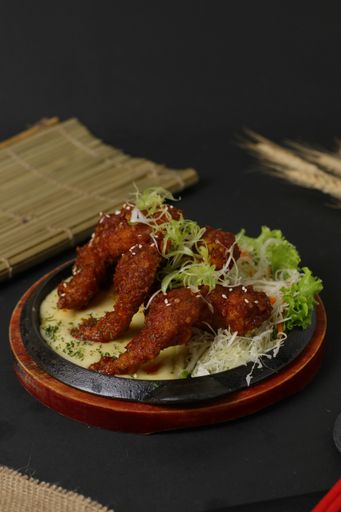 A vertical shot of fried Japanese chicken wings in a sauce served in the restaurant