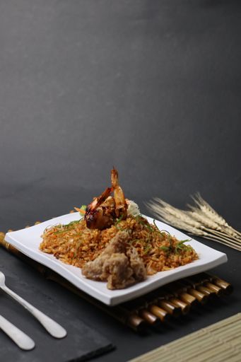 A vertical shot of a Japanese dish with rice and chicken wings on a white plate